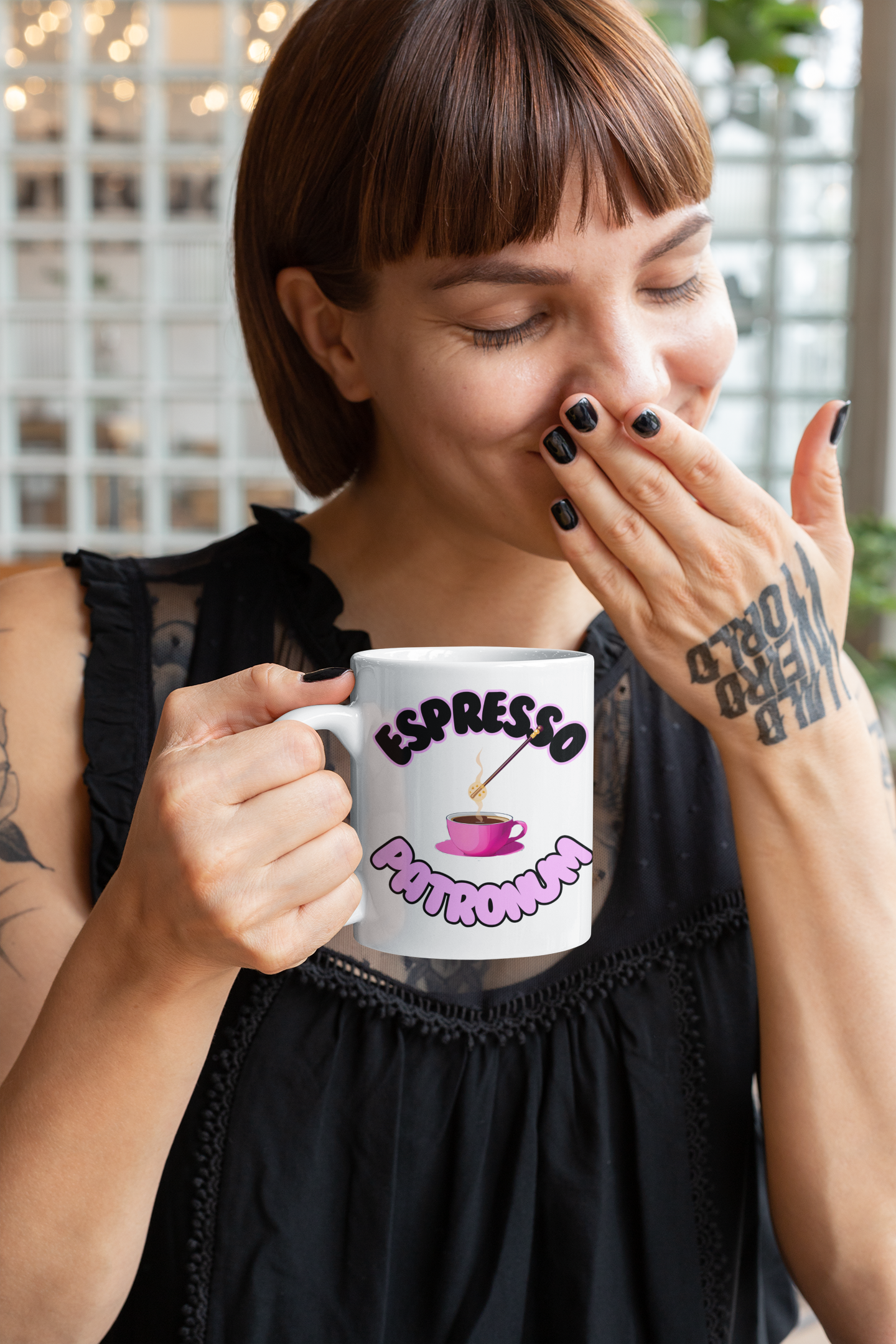 Tattooed woman smiles while holding the Gothic Espresso Patronum Mug for Morning Humor, perfect for a fun start to the day.